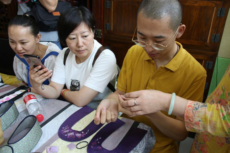 A participant in Great Seed’s intangible cultural heritage experience program works on the sole of a shoe, July 21, 2018. (Photo/chinadaily.com.cn)