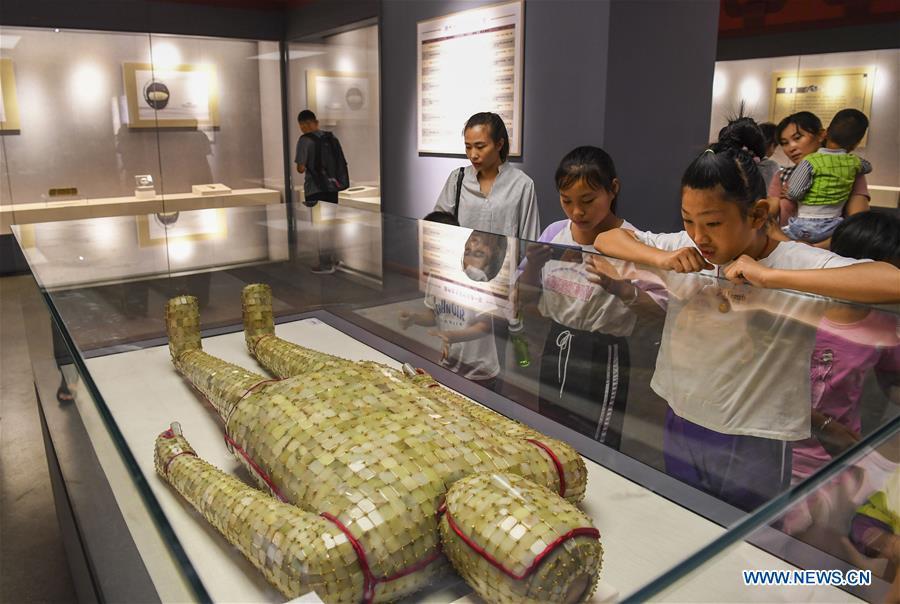 Visitors view a jade clothes sewn with gold wire dating back to the Western Han Dynasty at an exhibition in the Xinjiang Museum in Urumqi, capital of northwest China\'s Xinjiang Uygur Autonomous Region, July 25, 2018. Co-hosted by the Xinjiang Museum and the Xuzhou Museum, the exhibition kicked off on Wednesday. (Xinhua/Hu Huhu)
