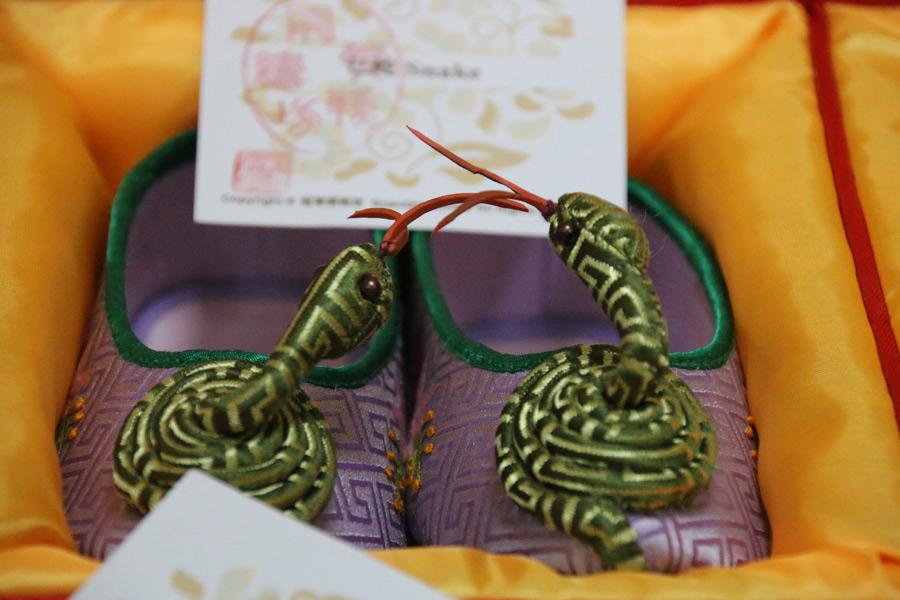A coiled snake from the Chinese zodiac rises from the toes of a pair of embroidered shoes made by Wang Guanqin, July 21, 2018. (Photo/chinadaily.com.cn)
In 2007, Wang\'s handmade embroidered shoes and her skills were placed on Beijing\'s Intangible Cultural Heritage list. She is said to be the premier figure in Chinese embroidered shoemaking.
Her shoes have now become precious gifts for people to give for special occasions, such as at weddings or to treasure as an art piece.
The Great Seed, a global community platform aimed at all intangible cultural heritage enthusiasts to communicate, share, experience and inherit intangible cultural heritage worldwide, is now recruiting people to be participants who will learn and experience such heritage.
Through June 9, 2019, 1,000 people around the world will be recruited to connect with 1,000 inheritors to have an in-depth experience with different forms of intangible cultural heritage.