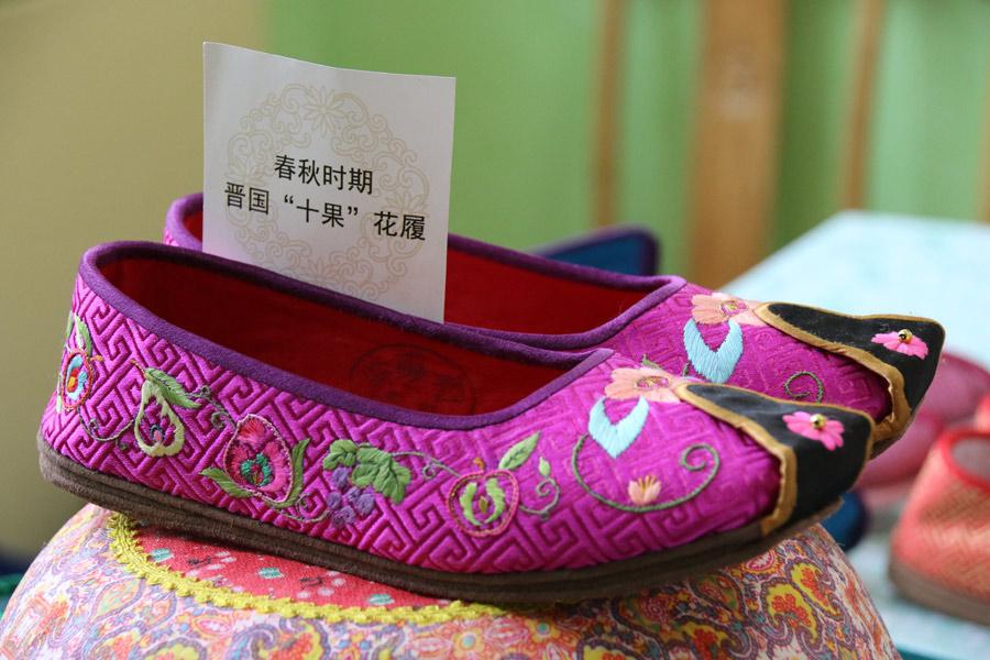 Chinese traditional handmade shoes made by Wang Guanqin and embroidered with 10 different kinds of fruit were inspired by the Spring and Autumn Period (770-476 BC), July 21, 2018. (Photo/chinadaily.com.cn)