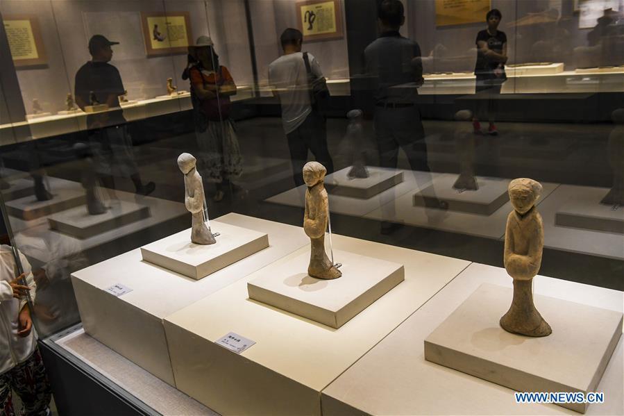 Visitors view pottery figurines dating back to the Western Han Dynasty at an exhibition in the Xinjiang Museum in Urumqi, capital of northwest China\'s Xinjiang Uygur Autonomous Region, July 25, 2018. Co-hosted by the Xinjiang Museum and the Xuzhou Museum, the exhibition kicked off on Wednesday. (Xinhua/Hu Huhu)