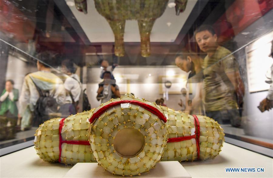 Visitors view a jade clothes sewn with gold wire dating back to the Western Han Dynasty at an exhibition in the Xinjiang Museum in Urumqi, capital of northwest China\'s Xinjiang Uygur Autonomous Region, July 25, 2018. Co-hosted by the Xinjiang Museum and the Xuzhou Museum, the exhibition kicked off on Wednesday. (Xinhua/Hu Huhu)