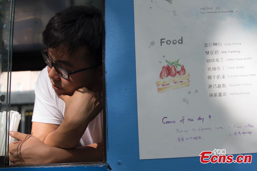 Food truck owner Fei Xiang exchanges free coffee for ten cigarette butts, picked up by customers in Flushing, New York City, U.S., July 26, 2018. Fei’s food truck offered customers free coffee in exchange for ten cigarette butts, picked up from around the community, as an initiative to improve the local environment. Fei said he delivered about five to ten cups of free coffee a day. (Photo: China News Service/Liao Pan)