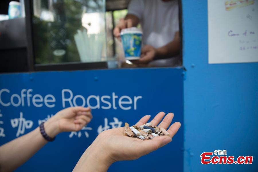 Food truck owner Fei Xiang exchanges free coffee for ten cigarette butts, picked up by customers in Flushing, New York City, U.S., July 26, 2018. Fei’s food truck offered customers free coffee in exchange for ten cigarette butts, picked up from around the community, as an initiative to improve the local environment. Fei said he delivered about five to ten cups of free coffee a day. (Photo: China News Service/Liao Pan)