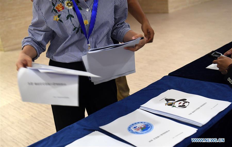 A journalist gets material concerning the mascot and logo of the China International Import Expo (CIIE) in Shanghai, east China, July 27, 2018. China unveiled the mascot and the logo for the expo here on Friday. (Xinhua/Jin Liangkuai)