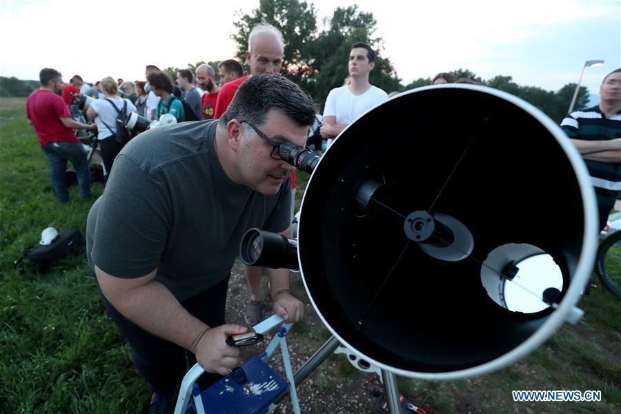 People watch the longest total lunar eclipse of the century at Jarun Lake in Zagreb, capital of Croatia, on July 27, 2018. (Xinhua/Igor Kralj)