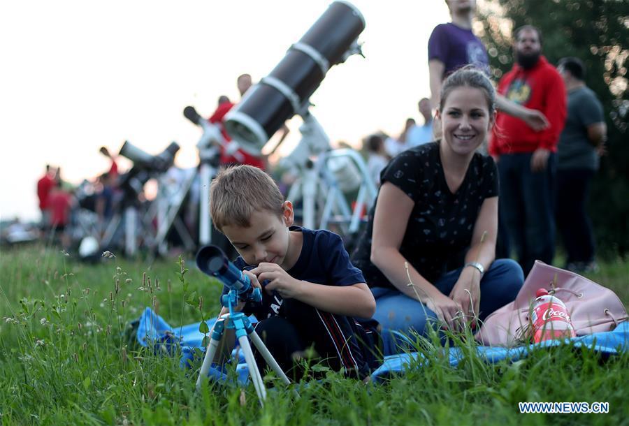 People watch the longest total lunar eclipse of the century at Jarun Lake in Zagreb, capital of Croatia, on July 27, 2018. (Xinhua/Igor Kralj)
