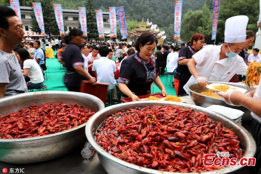 A crayfish banquet is held on Laojun Mountain in Luoyang City, Central China’s Henan Province, July 28, 2018. Organizers prepared more than 1,000 kilograms of crayfish and another 1,000 kilograms of fruit, as well as providing beer, to entertain thousands of visitors, who quickly gobbled up the treats. (Photo/IC)