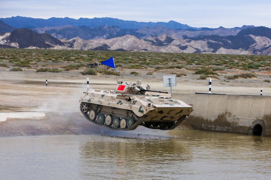 An infantry fighting vehicle (right) of the People\'s Liberation Army participates in the Suvorov Attack race during the International Army Games 2018 in Korla, Xinjiang Uygur autonomous region on Monday.(Photo/China Daily)