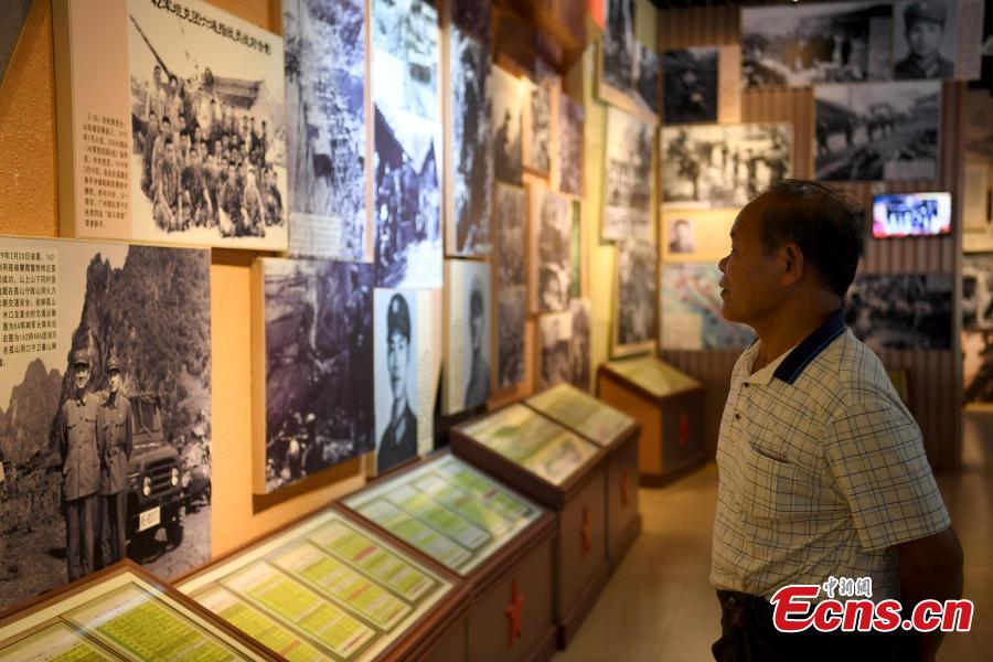 Niu Bentong looks at photos depicting the China-Vietnam war in Longzhou County, South China’s Guangxi Zhuang Autonomous Region, July 30, 2018. Niu participated in the China-Vietnam war and witnessed the death of many of his comrades-in-arms in front of him. In 1980, Niu chose to work in the cemetery, where 1,902 martyrs lie, and he continued to work there for 37 years until his retirement this year. He has helped correct information related to more than 400 martyrs and has also shared details online. In his spare time, Niu continues to help at the cemetery, saying it’s hard to forget the days of life and death spent alongside his fellow soldiers. (Photo: China News Service/Yu Jing)