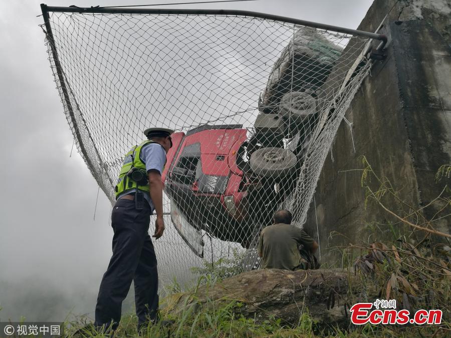 A cargo truck’s cabin hangs on a slip road in Yuxi City, Southwest China’s Yunnan Province, July 26, 2018. Having lost control of the truck on a 27-kilometer-long downward slope, known as the \