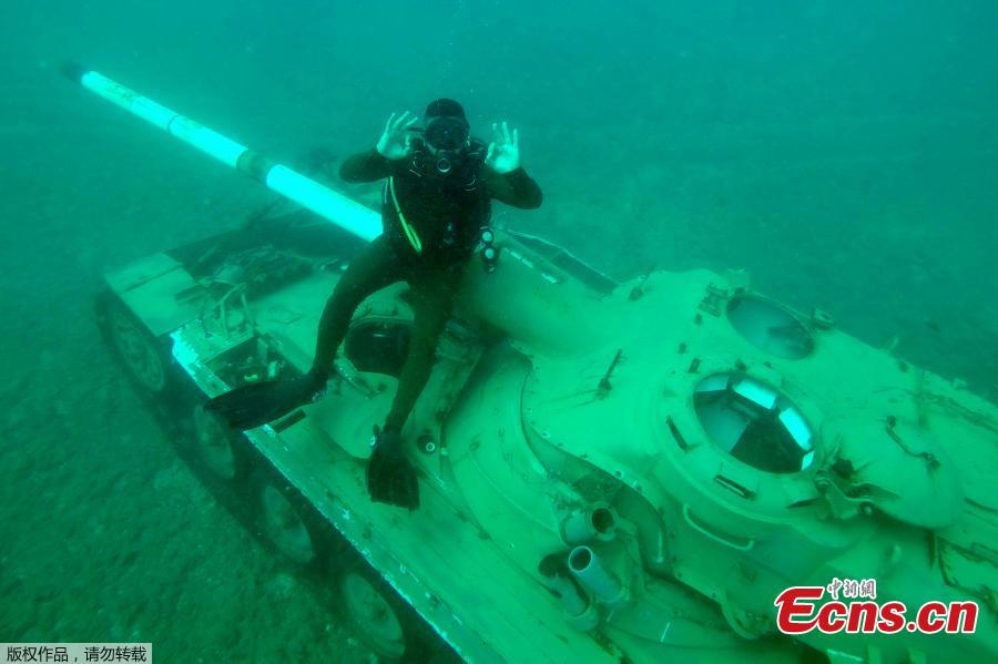 A diver gestures near an immersed tank off the coast of Sidon, Lebanon, July 28, 2018. Lebanese environmentalists sank 10 old tanks and other armored vehicles to the bottom of the Mediterranean Sea in a novel attempt to attract divers and create new habitats for marine life. (Photo/Agencies)