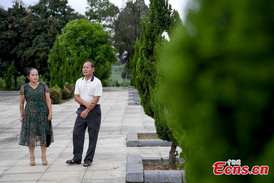 Niu Bentong talks to a visitor at a martyrs cemetery in Longzhou County, South China’s Guangxi Zhuang Autonomous Region, July 30, 2018. Niu participated in the China-Vietnam war and witnessed the death of many of his comrades-in-arms in front of him. In 1980, Niu chose to work in the cemetery, where 1,902 martyrs lie, and he continued to work there for 37 years until his retirement this year. He has helped correct information related to more than 400 martyrs and has also shared details online. In his spare time, Niu continues to help at the cemetery, saying it’s hard to forget the days of life and death spent alongside his fellow soldiers. (Photo: China News Service/Yu Jing)