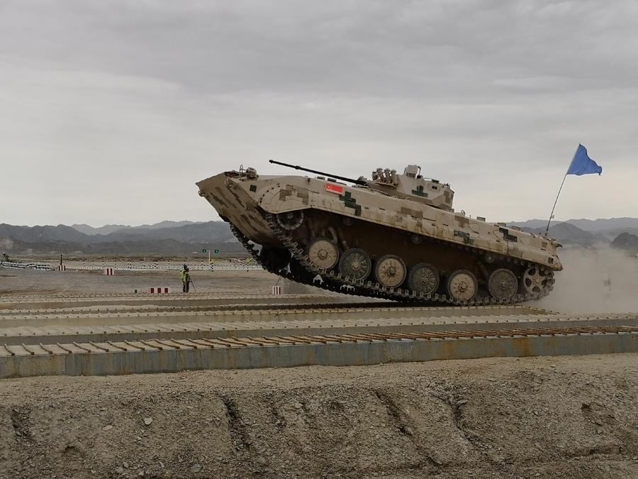 An infantry fighting vehicle (right) of the People\'s Liberation Army participates in the Suvorov Attack race during the International Army Games 2018 in Korla, Xinjiang Uygur autonomous region on Monday.(Photo/China Daily)