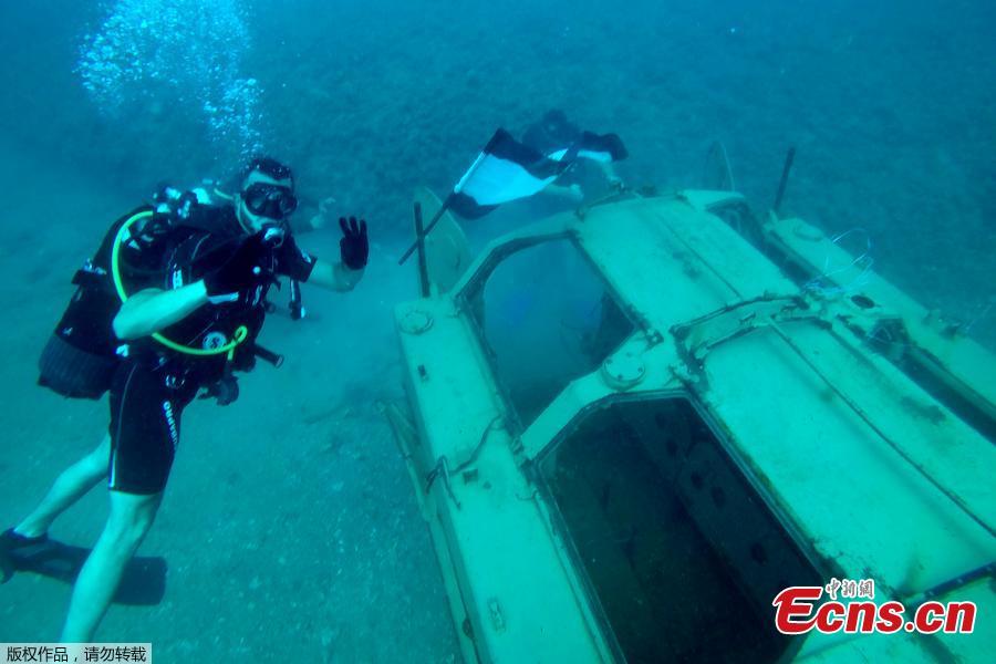 A diver gestures near an immersed tank off the coast of Sidon, Lebanon, July 28, 2018. Lebanese environmentalists sank 10 old tanks and other armored vehicles to the bottom of the Mediterranean Sea in a novel attempt to attract divers and create new habitats for marine life. (Photo/Agencies)