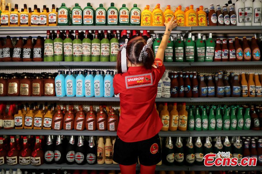 British artist Lucy Sparrow, 32, adjusts bottles of alcohol on shelves in her art installation supermarket in which everything is made of felt, in Los Angeles, California, U.S. July 31, 2018. (Photo/Agencies)