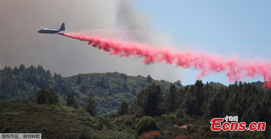 An aircraft drops fire retardant to slow the spread of the Carr Fire, west of Redding, California, U.S. July 27, 2018. A 70-year-old woman and her two great-grandchildren were among six people killed when a wildfire engulfed entire communities in northern California, officials and family members said. (Photo/Agencies)