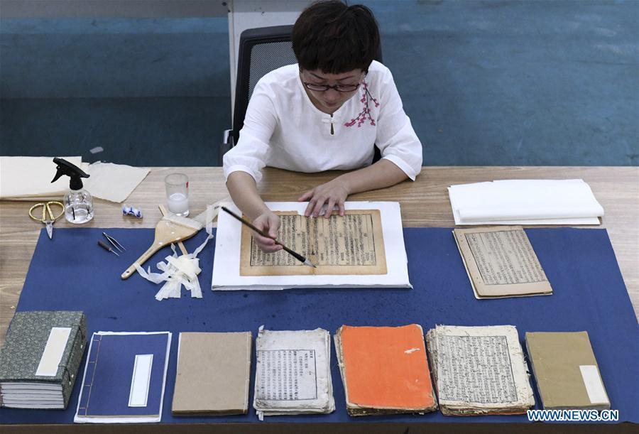 Gao Huiyun restores an ancient book at a workshop in Shijiazhuang, capital of north China\'s Hebei Province, Aug. 2, 2018. Gao Huiyun is a teacher of cultural relics restoration and protection at Hebei Vocational Art College. Gao has restored over 1,000 ancient books in her 13-year career time. (Xinhua/Chen Qibao)
