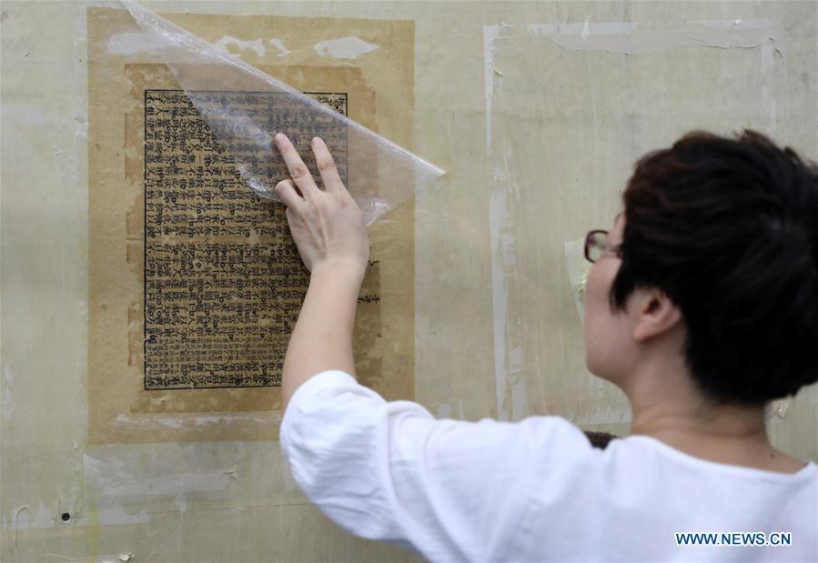 Gao Huiyun restores an ancient book at a workshop in Shijiazhuang, capital of north China\'s Hebei Province, Aug. 2, 2018. Gao Huiyun is a teacher of cultural relics restoration and protection at Hebei Vocational Art College. Gao has restored over 1,000 ancient books in her 13-year career time. (Xinhua/Chen Qibao)