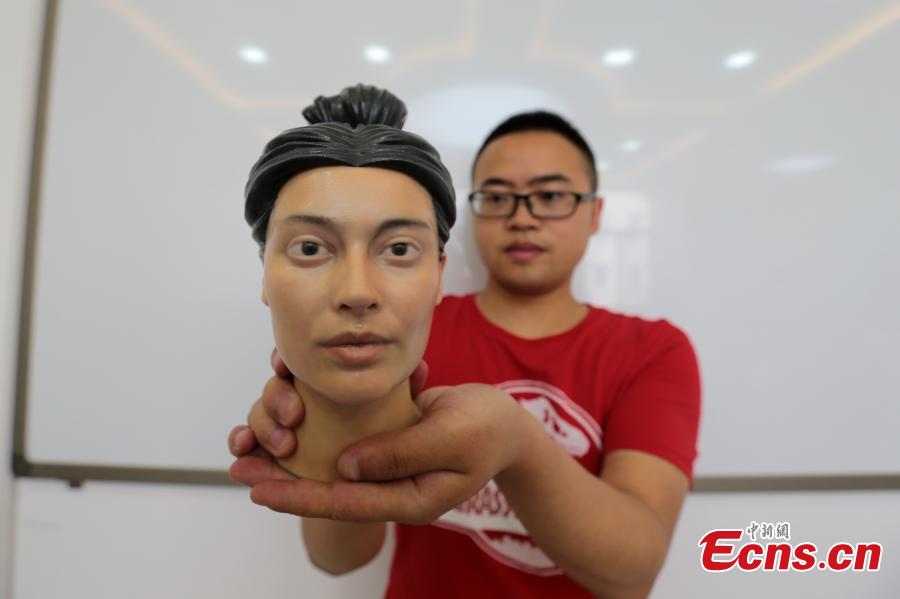 A student shows a head sculpture of a woman from the Qin Dynasty (221 to 206 BC) made using 3D-printing technology in Northwest University in Xi’an City, Shaanxi Province, Aug. 2, 2018. Through \