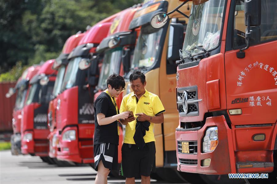 A staff member helps truck driver Li Haijun (R) use the Truck Alliance app, China\'s Uber-type service for trucks, with smartphone in Guiyang, capital of southwest China\'s Guizhou Province, Aug. 1, 2018. Guizhou has become a pioneer in China\'s big data development. Big data is being widely applied in government management, business and daily life, contributing over 20 percent to the economic growth of Guizhou Province. The number of big data-related companies in Guizhou Province has grown from less than 1,000 in 2013 to more than 8,500 in 2018. (Xinhua/Liu Xu)