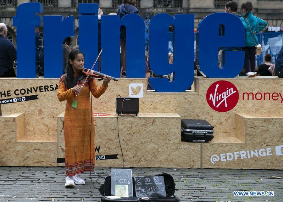 A woman plays violin on the opening day of the Edinburgh Festival Fringe 2018 in Edinburgh, Scotland, Britain on Aug. 3, 2018. (Xinhua/Han Yan)