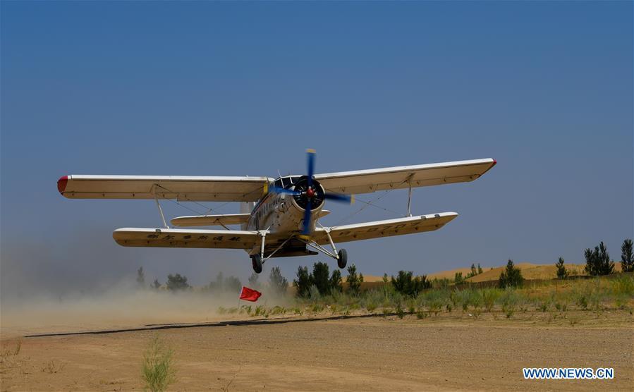 A plane takes off to sow seeds at the Kubuqi Desert in Erdos, north China\'s Inner Mongolia Autonomous Region, July 11, 2018. Kubuqi, the seventh largest desert in China, is a good example of China\'s success in alleviating desertification. About 6,460 square kilometers of the Kubuqi desert has been reclaimed in the last 30 years. (Xinhua/Peng Yuan)