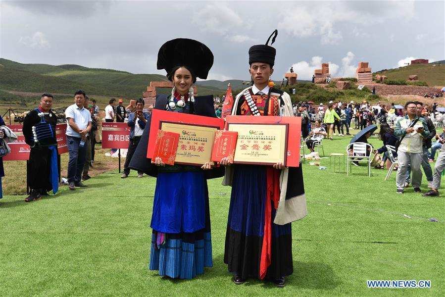 Winners of a beauty contest receive awards during the torch festival of Yi ethnic group on a grassland in Zhaojue County, southwest China\'s Sichuan Province, Aug. 6, 2018. (Xinhua/Lyu Mingze)