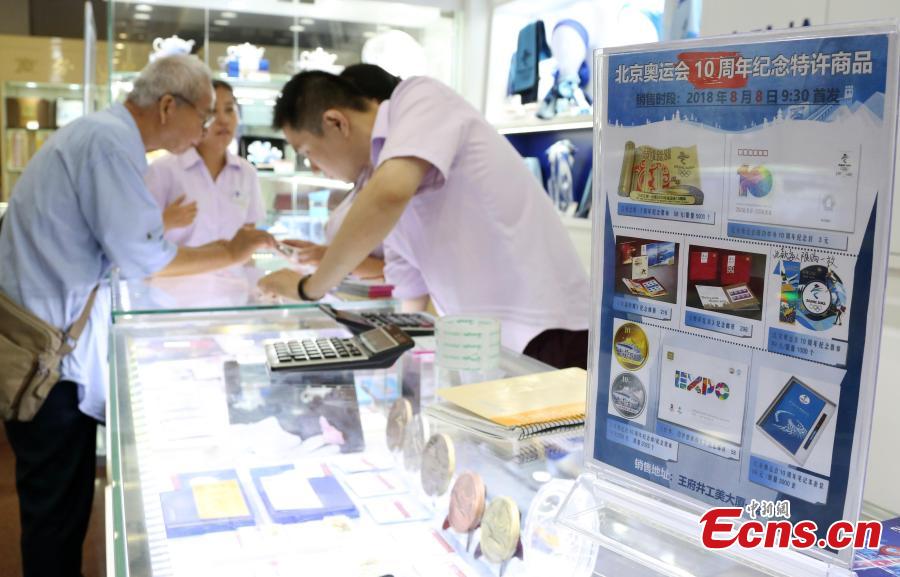 Customers buy souvenirs released by the Beijing Organizing Committee for the 2022 Olympic and Paralympic Winter Games to mark the 10thanniversary of Beijing’s hosting of the 2008 Summer Olympics in the Gongmei Building in Wangfujing, Beijing, Aug. 8, 2018. (Photo: China News Service/Ren Haixia)