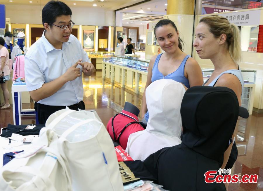 Customers buy souvenirs released by the Beijing Organizing Committee for the 2022 Olympic and Paralympic Winter Games to mark the 10thanniversary of Beijing’s hosting of the 2008 Summer Olympics in the Gongmei Building in Wangfujing, Beijing, Aug. 8, 2018. (Photo: China News Service/Ren Haixia)