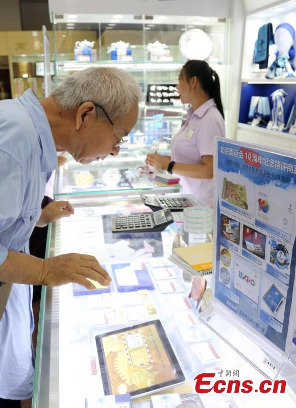 Customers buy souvenirs released by the Beijing Organizing Committee for the 2022 Olympic and Paralympic Winter Games to mark the 10thanniversary of Beijing’s hosting of the 2008 Summer Olympics in the Gongmei Building in Wangfujing, Beijing, Aug. 8, 2018. (Photo: China News Service/Ren Haixia)