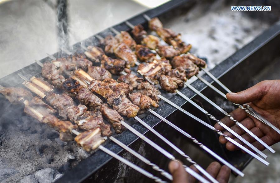 A cook makes grilled lamb chops in Changji, northwest China\'s Xinjiang Uygur Autonomous Region, April 28, 2017. (Xinhua/Zhao Ge)