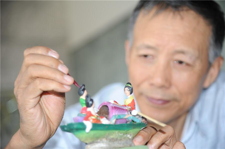 Liu Zhenyuan works on his artwork. (Photo by Zhang Qingyun/for or chinadaily.com.cn)
Liu Zhenyuan from Harbin, capital city of Heilongjiang province, recently finished the landscape artwork on a miniature version of the Grand View Garden, or Daguanyuan, a major setting in the classic Chinese novel The Dream of Red Mansions.
The 67-year-old retired photographer was drawn to the story after watching a TV adaptation four years ago, and had the idea of making a miniature landscape of the Grand View Garden.
After four years of work, he designed and created thousands of elements, which formed more than one hundred scenes from the story.