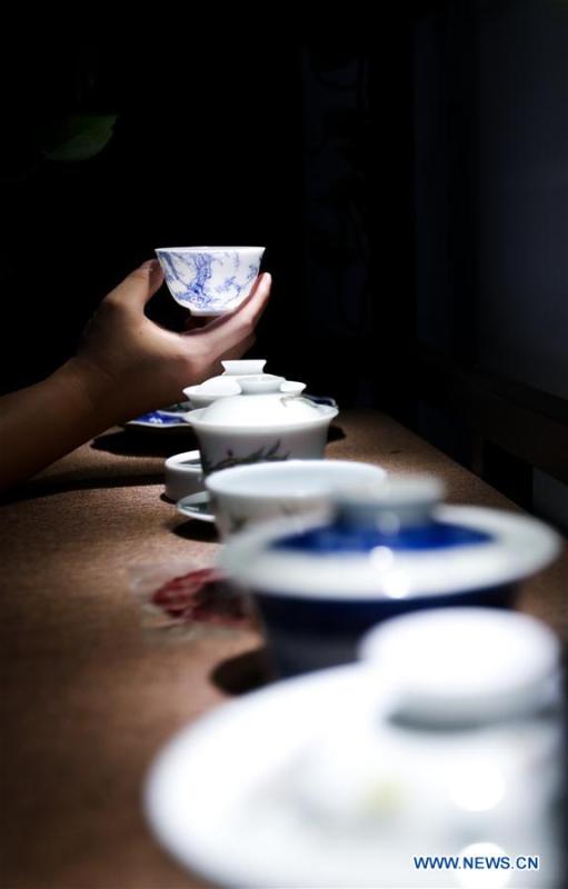 A visitor watches a tea cup made by the \