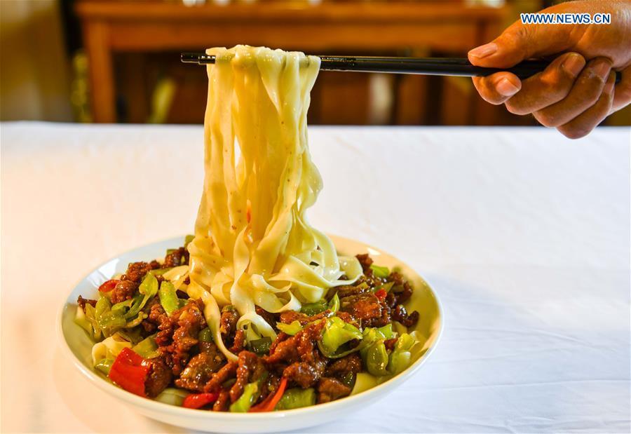 A cook shows a local dish of noodles at a restaurant in Qitai, northwest China\'s Xinjiang Uygur Autonomous Region, July 25, 2018. (Xinhua/Wang Fei)