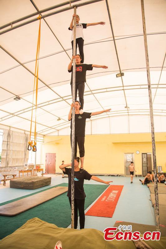 Acrobat Li Xianhui, 22, trains with other members at a gym in Nanning, the capital of South China’s Guangxi Zhuang Autonomous Region, Aug. 9, 2018. Most of the children training with the acrobatics troupe led by Li Dewei are from the poverty-stricken Mashan County and they dream of one day improving the financial position of their families through their performances. A member of the acrobatics troupe for ten years, Li has performed in many countries. (Photo: China News Service/Chen Guanyan)