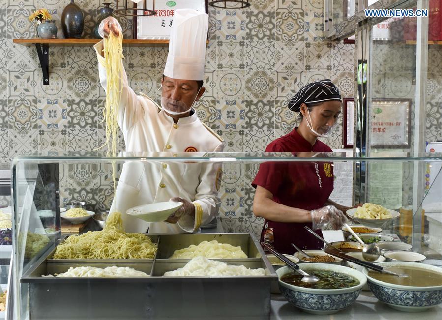 Cooks make cold noodles at a restaurant in Qitai County, northwest China\'s Xinjiang Uygur Autonomous Region, July 25, 2018. (Xinhua/Zhao Ge)