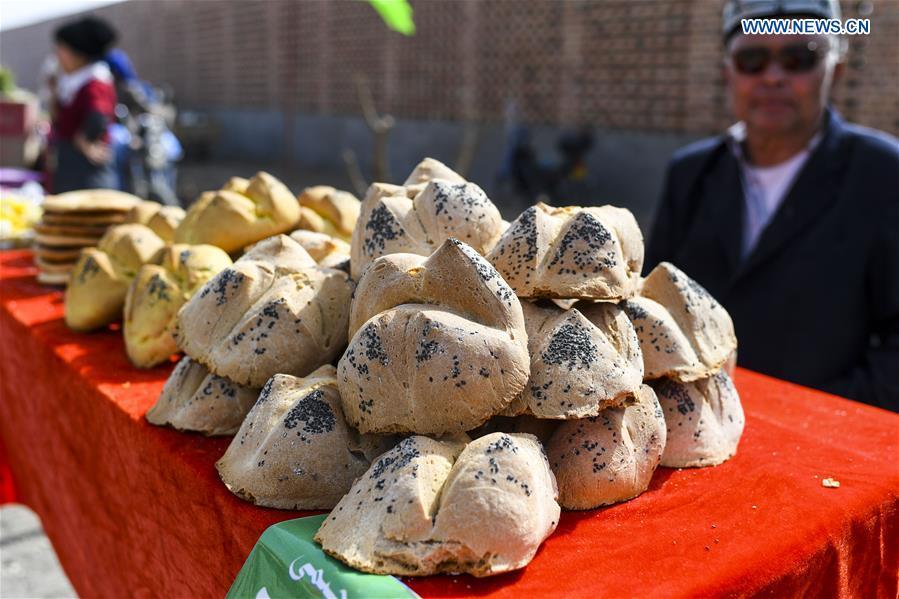 A vendor sells Nang, a kind of crusty cake, at a bazaar in Turpan, northwest China\'s Xinjiang Uygur Autonomous Region, March 14, 2017. (Xinhua/Wang Fei)