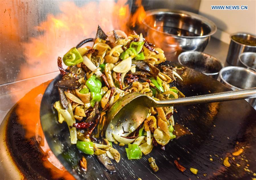 A cook makes a dish at a restaurant in Qitai County, northwest China\'s Xinjiang Uygur Autonomous Region, July 25, 2018. (Xinhua/Zhao Ge)