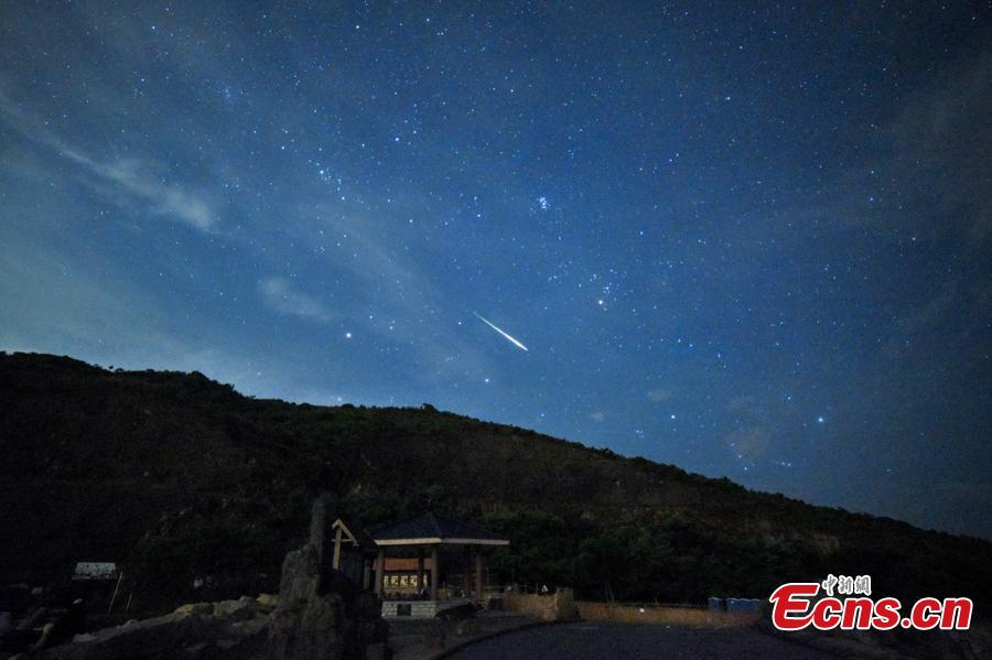 A meteor streaks past stars in the night sky during the Perseid meteor shower in Hong Kong, August 13, 2018. (Photo: China News Service/ Sheung Man Mak)