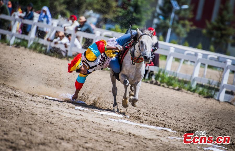 An equestrian puts on a display of traditional horsemanship skills during the Shoton Festival, commonly known as the Yogurt Festival, in Lhasa, Southwest China’s Tibet Autonomous Region, Aug. 13, 2018. Equestrians performed ten kinds of stunts while riding a horse, including archery and toasting. (Photo: China News Service/He Penglei)