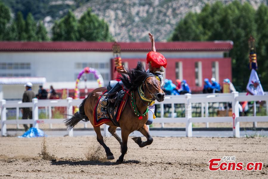 An equestrian puts on a display of traditional horsemanship skills during the Shoton Festival, commonly known as the Yogurt Festival, in Lhasa, Southwest China’s Tibet Autonomous Region, Aug. 13, 2018. Equestrians performed ten kinds of stunts while riding a horse, including archery and toasting. (Photo: China News Service/He Penglei)