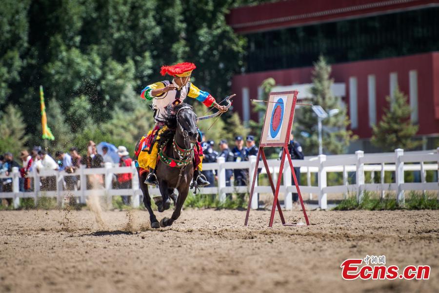 An equestrian puts on a display of traditional horsemanship skills during the Shoton Festival, commonly known as the Yogurt Festival, in Lhasa, Southwest China’s Tibet Autonomous Region, Aug. 13, 2018. Equestrians performed ten kinds of stunts while riding a horse, including archery and toasting. (Photo: China News Service/He Penglei)