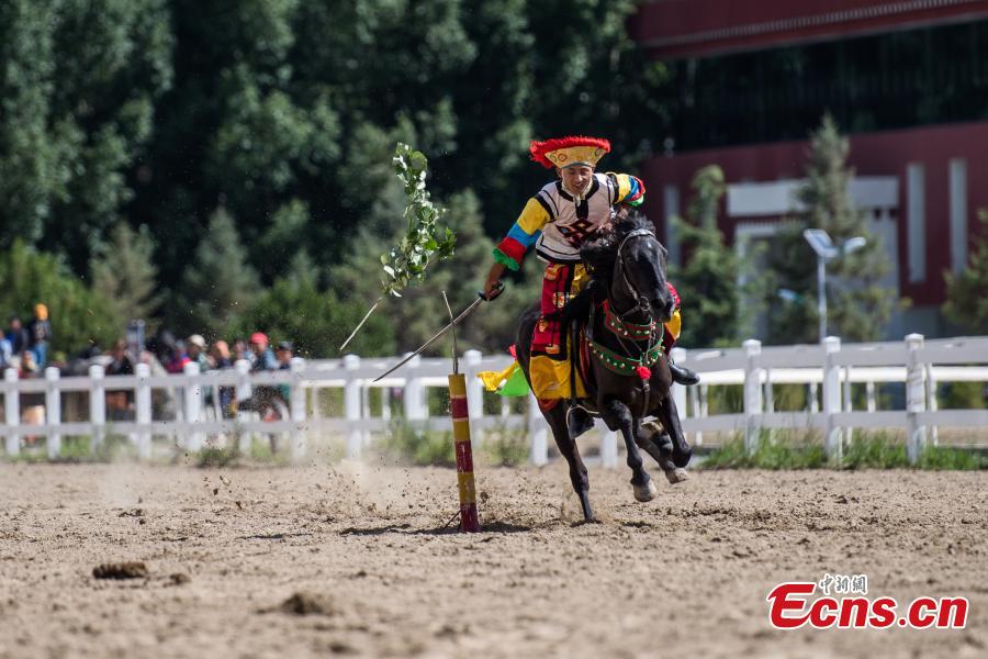 An equestrian puts on a display of traditional horsemanship skills during the Shoton Festival, commonly known as the Yogurt Festival, in Lhasa, Southwest China’s Tibet Autonomous Region, Aug. 13, 2018. Equestrians performed ten kinds of stunts while riding a horse, including archery and toasting. (Photo: China News Service/He Penglei)