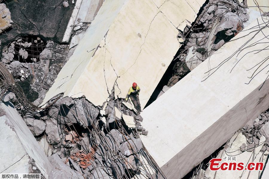 Rescue workers search on the site of the collapsed Morandi Bridge in the port city of Genoa, Italy August 14, 2018.The bridge connects the highway A10 to the western part of the city, near a populous neighborhood called Sampierdarena. At least 26 people were killed in the accident. (Photo/Agencies)