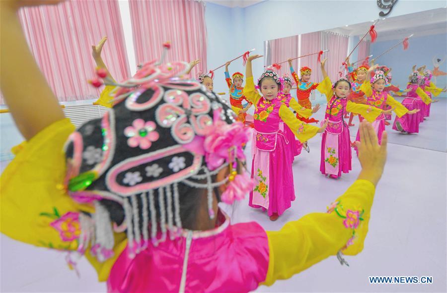 Students learn basic skills of traditional Chinese opera at a primary school in Hanshan District of Handan, north China\'s Hebei Province, Aug. 14, 2018. The school organized traditional Chinese arts activities for students to enrich their summer vacation life. (Xinhua/Wang Xiao)