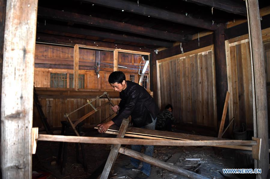 A villager does carpenter work at an old wooden house in reform in Zaidang, Qiandongnan of southwest China\'s Guizhou Province, Aug. 14, 2018. Zaidang, a village of Dong ethnic group, has encouraged its villagers to make use of idle resources to upgrade local infrastructure, in an aim to develop tourism industry and shake off poverty. (Xinhua/Wang Bingzhen)