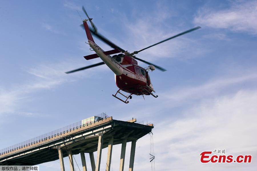 Fire fighters inspect from the helicopter the site of the collapsed Morandi Bridge in the port city of Genoa, Italy August 14, 2018. The bridge connects the highway A10 to the western part of the city, near a populous neighborhood called Sampierdarena. At least 26 people were killed in the accident. (Photo/Agencies)