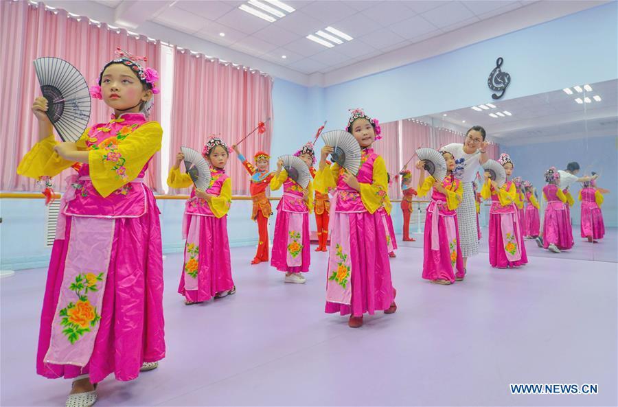 Students learn basic skills of traditional Chinese opera at a primary school in Hanshan District of Handan, north China\'s Hebei Province, Aug. 14, 2018. The school organized traditional Chinese arts activities for students to enrich their summer vacation life. (Xinhua/Wang Xiao)