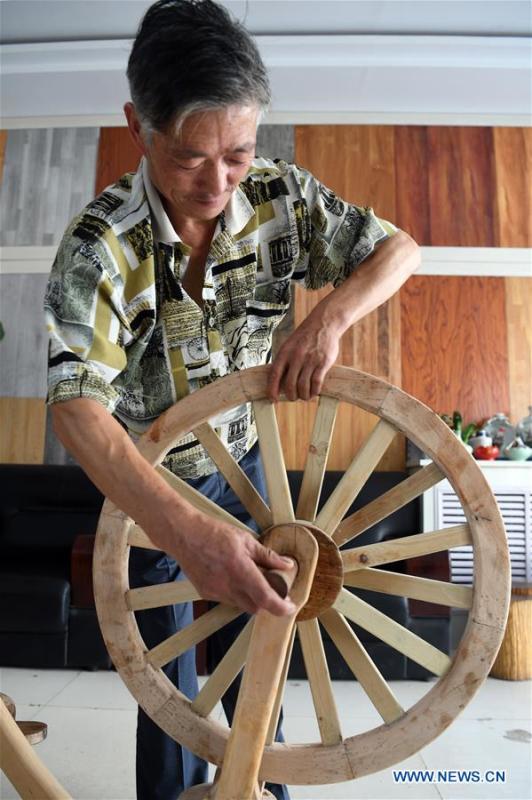 He Yong assembles the parts of a wooden bicycle in Liuhu Township of Pingliang City, northwest China\'s Gansu Province, Aug. 14, 2018. The 55-year-old farmer He Yong successfully made a 1.8-meter-long and 0.98-meter-high wooden bicycle in 2017. The bike was made purely of wood, including walnut and elm. (Xinhua/Fan Peishen)
